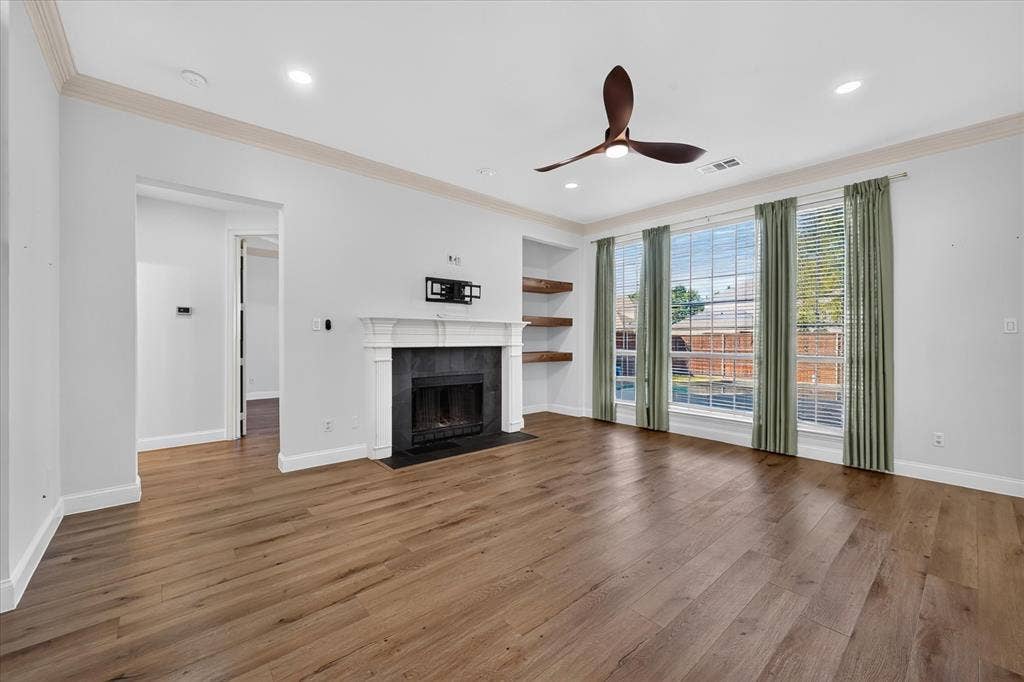 10601 Whispering Pines Drive, Frisco, TX 75033 Wood-finish flooring, recessed lighting, and a fireplace with a dark stone surround