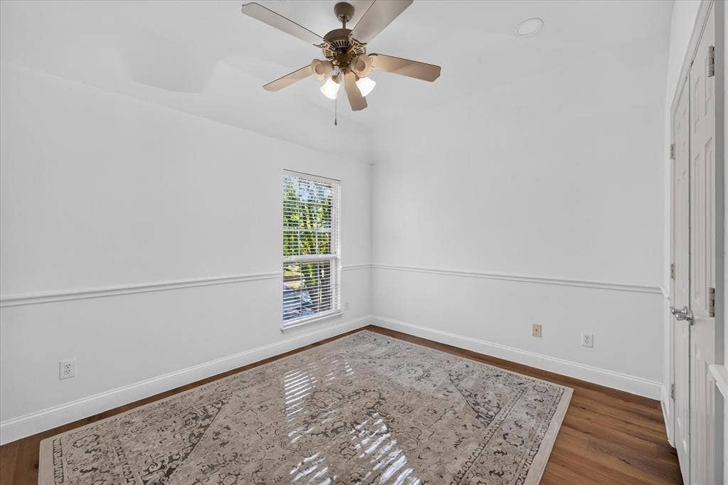 10601 Whispering Pines Drive, Frisco, TX 75033 Recessed ceiling with a ceiling fan, hardwood flooring, natural light through a window with blinds, and white interior walls featuring chair rail molding