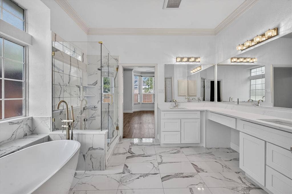 10601 Whispering Pines Drive, Frisco, TX 75033 Freestanding soaking tub, walk-in shower with clear glass enclosure, dual vanity sinks, and expansive vanity mirrors