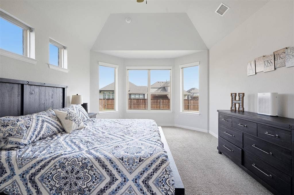 Vaulted ceiling, bay windows, high wall windows, light-colored carpet flooring, and recessed lighting