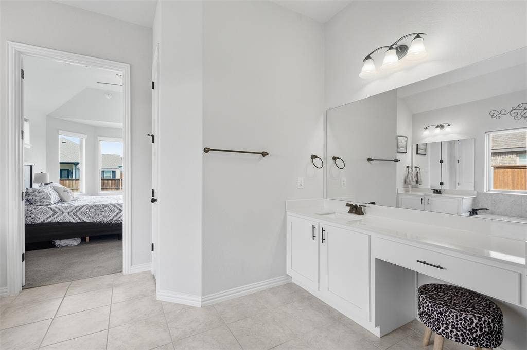 White cabinetry with dark hardware and a vanity area