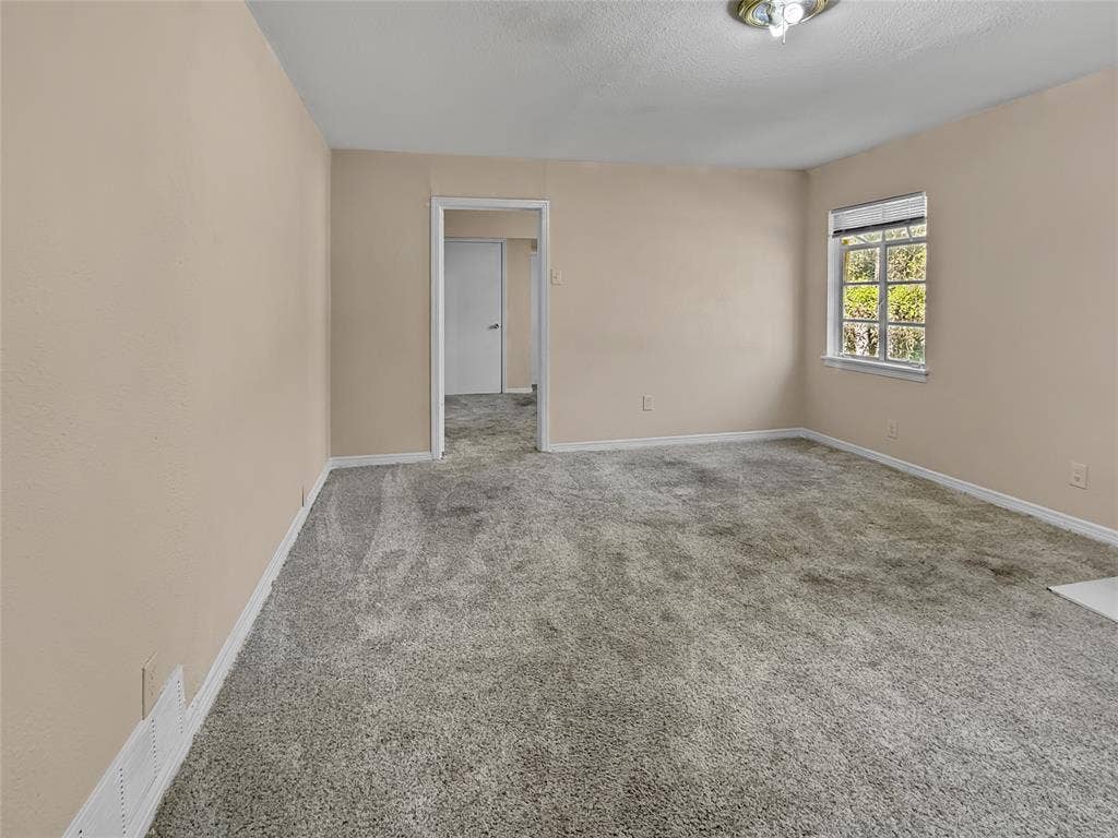 Window with natural light, neutral wall colors, carpeted flooring, white trim, and a ceiling-mounted light fixture