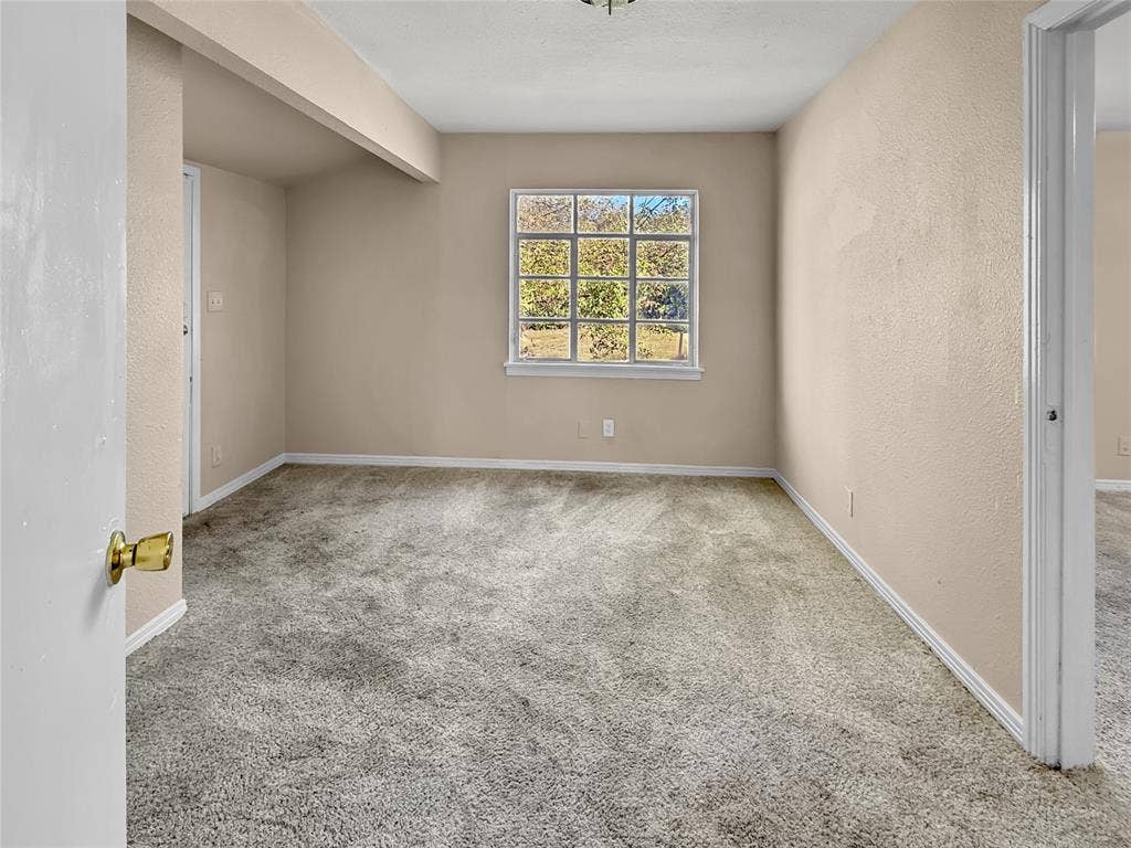 Carpeted interior with neutral wall finishes and a multi-pane window