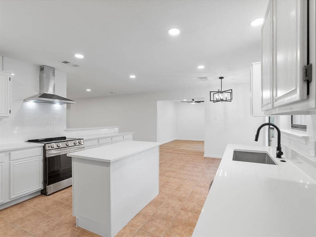 6716 Gold Dust Trail, Dallas, TX 75252 Kitchen featuring white shaker cabinetry, white subway tile backsplash, stainless steel range with ventilation hood, and white countertops