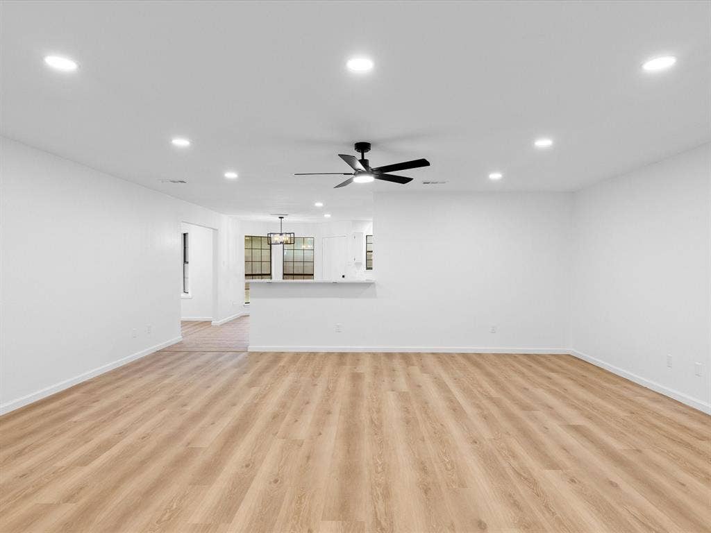 6716 Gold Dust Trail, Dallas, TX 75252 Recessed ceiling lighting, wood-finish flooring, ceiling fan, white wall finishes, and a partial wall with a countertop