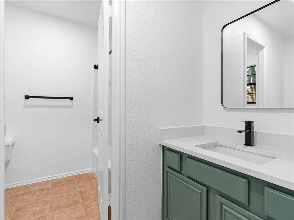 6716 Gold Dust Trail, Dallas, TX 75252 Vanity with a light green finish, white countertop, integrated sink, and matte black faucet