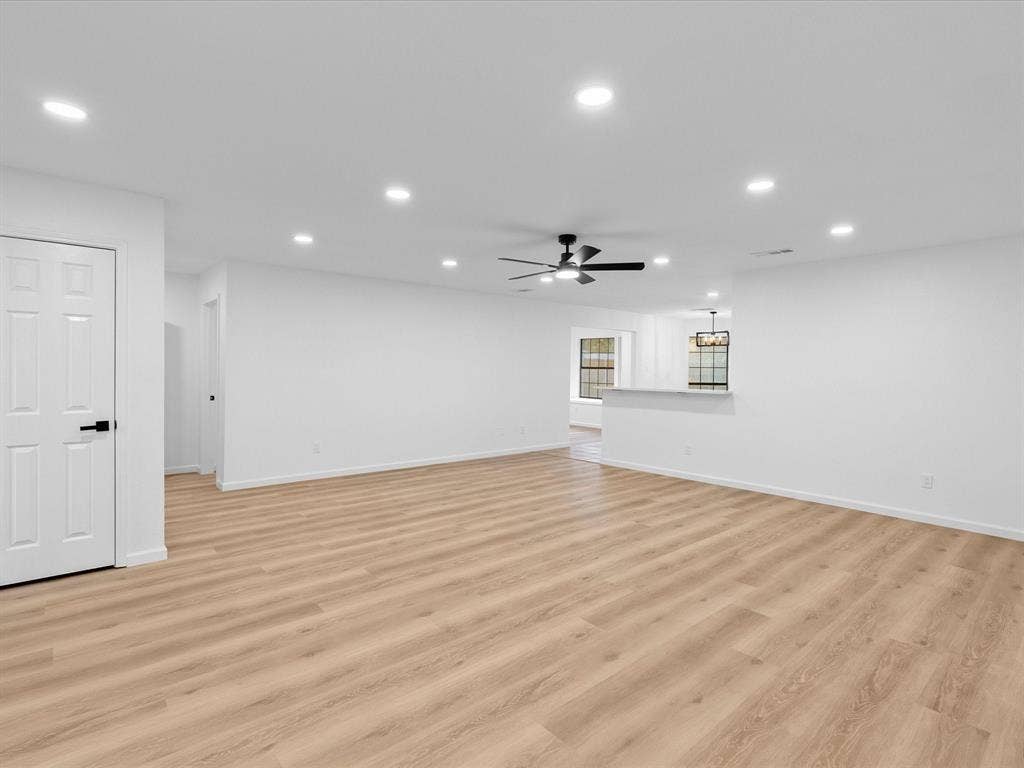 Spacious living area featuring wood-finish flooring, recessed lighting, and a modern ceiling fan