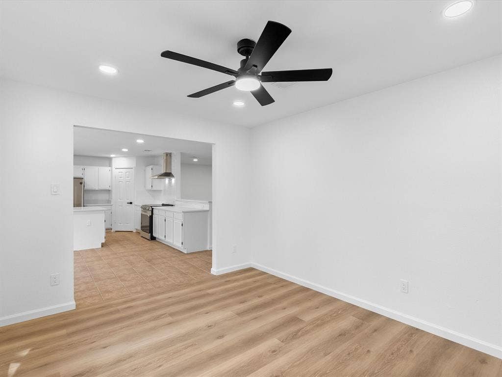 Open concept layout with wood-finish flooring, recessed lighting, and a contemporary ceiling fan