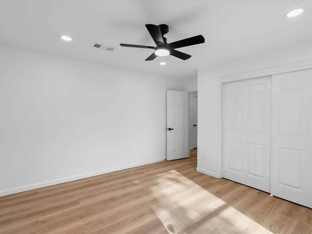 Wood-finish flooring, recessed lighting, and a contemporary ceiling fan