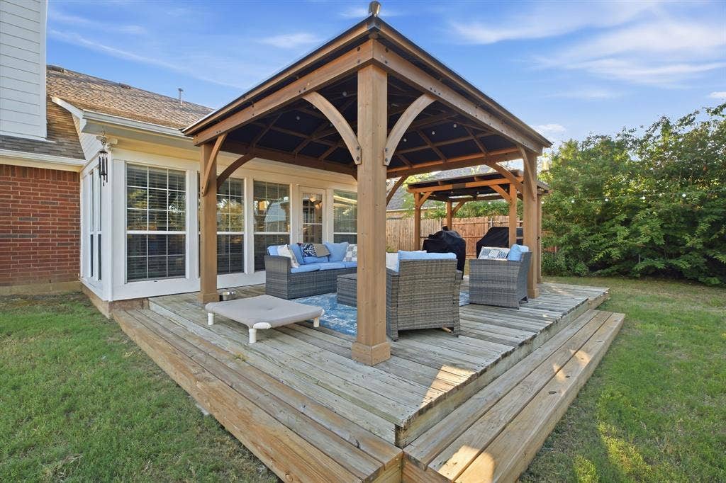 506 Amy Jo Circle, Aubrey, TX 76227 Expansive wooden deck with two integrated gazebos, accessible via French doors, featuring a brick exterior