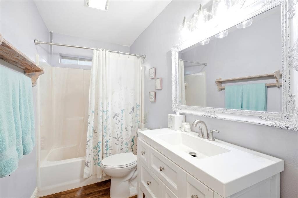 506 Amy Jo Circle, Aubrey, TX 76227 White vanity with integrated sink, brushed nickel faucet, large ornate framed mirror, and wood-finish flooring