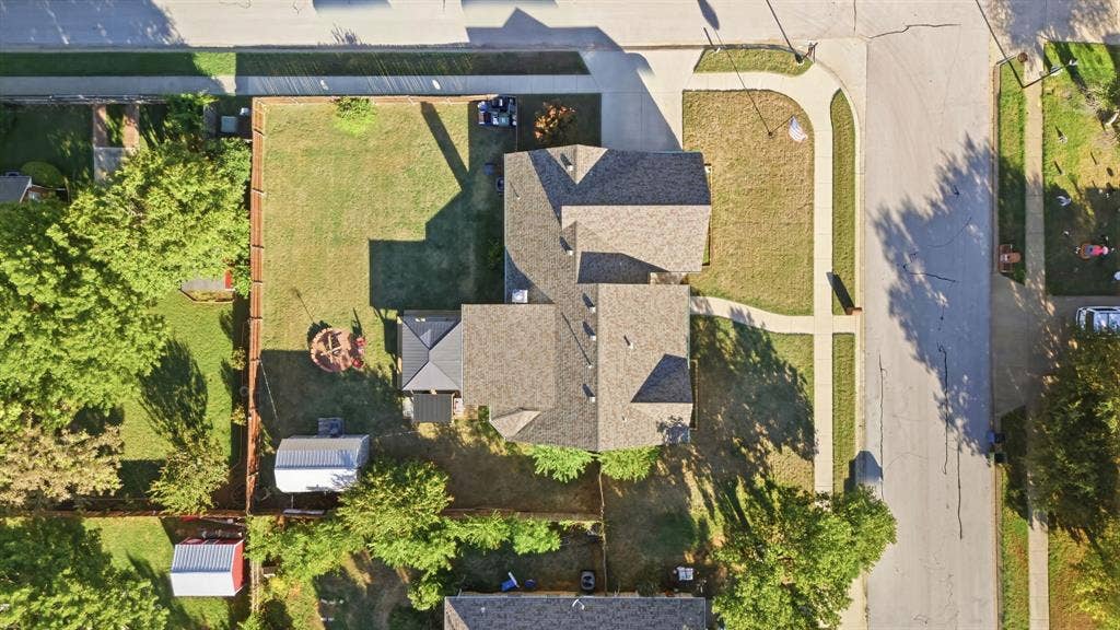506 Amy Jo Circle, Aubrey, TX 76227 Aerial view showcasing a multi-level residence with complex architectural design, featuring multiple roof peaks and dormers, mature landscaping with established trees throughout the grounds, and a spacious lot with manicured lawn areas and defined hardscaping elements