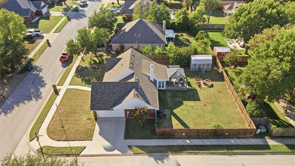 506 Amy Jo Circle, Aubrey, TX 76227 Expansive fenced backyard featuring a fire pit, mature trees, and a detached storage shed