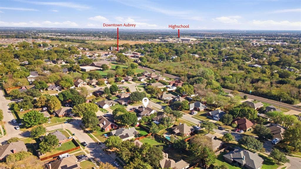 506 Amy Jo Circle, Aubrey, TX 76227 Aerial perspective of the surrounding area featuring residential streets, mature trees, and a distant commercial building