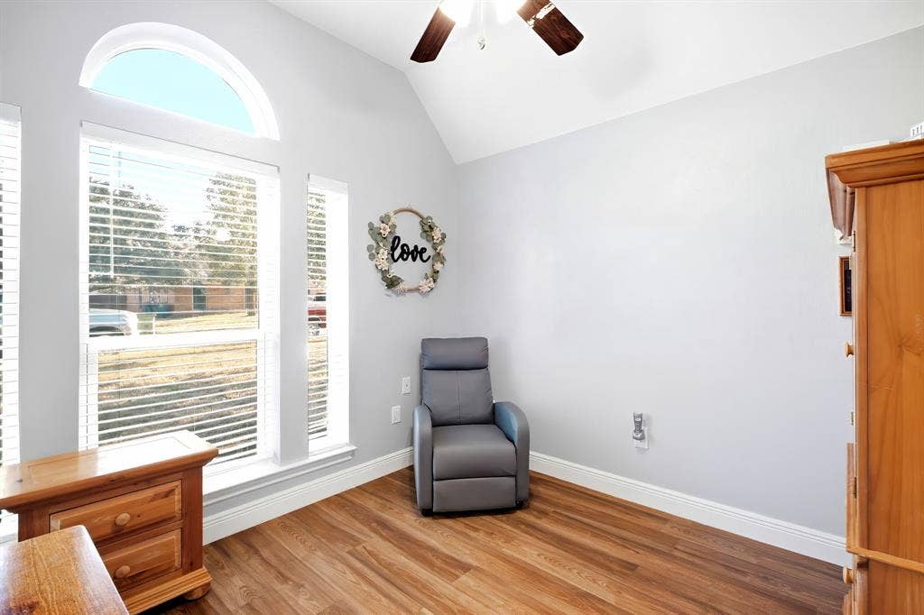 506 Amy Jo Circle, Aubrey, TX 76227 Vaulted ceiling with a ceiling fan, multiple windows including an arched transom, wood-finish flooring, and white trim
