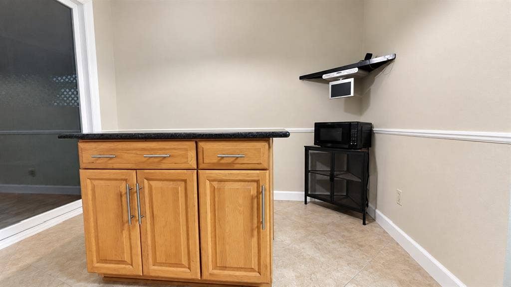 with a granite cabinet, Microwave and Smal player