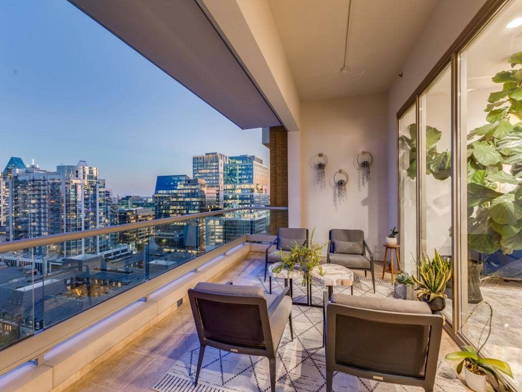 2300 Wolf Street, #14A, Dallas, TX 75201 Expansive outdoor terrace featuring a glass railing, city skyline backdrop, and large format tile flooring