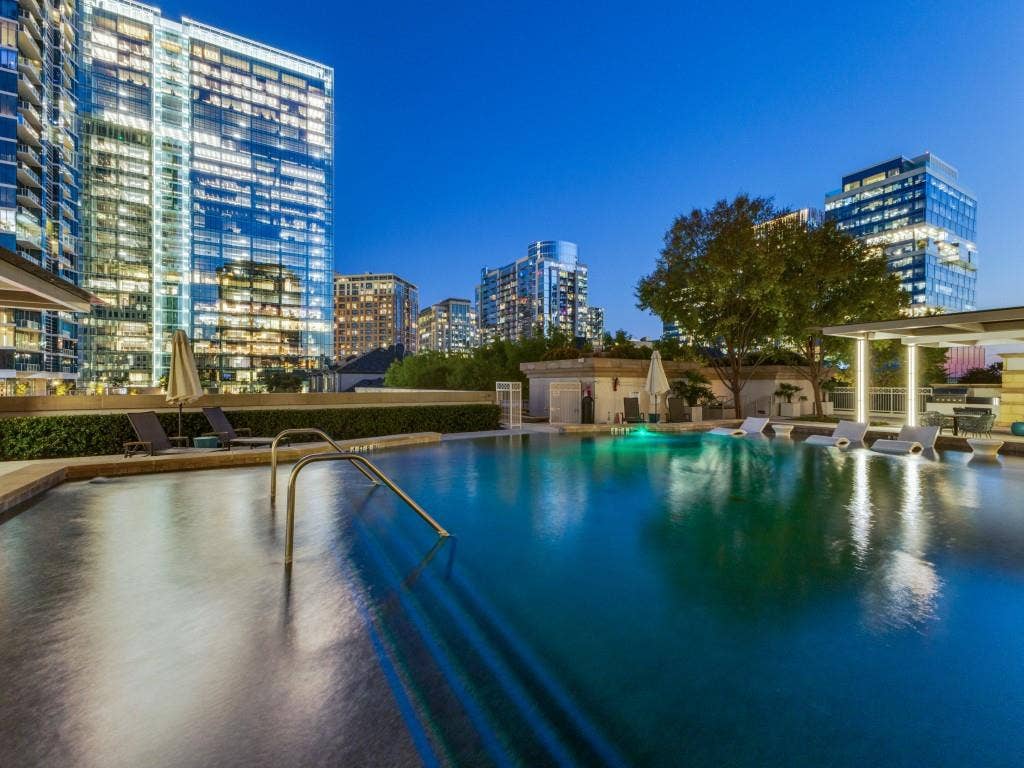 2300 Wolf Street, #14A, Dallas, TX 75201 Rooftop swimming pool with built-in lounge seating, surrounded by architectural landscaping and contemporary high-rise buildings