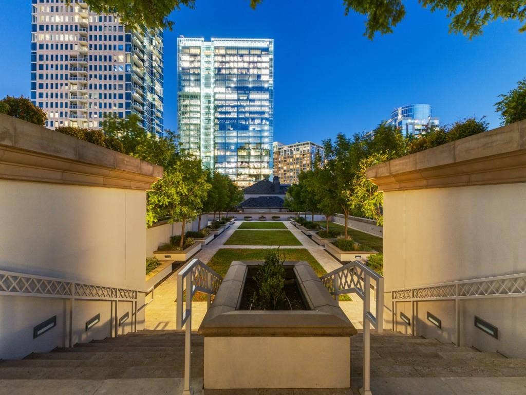 2300 Wolf Street, #14A, Dallas, TX 75201 Tiered outdoor space featuring a central lawn, mature plantings, and integrated lighting within concrete walls