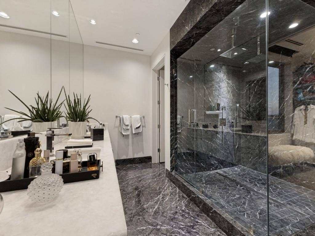 2300 Wolf Street, #14A, Dallas, TX 75201 Spacious bathroom featuring a dual vanity, floor-to-ceiling mirrors, recessed lighting, and a large walk-in shower with dark marbled walls and flooring