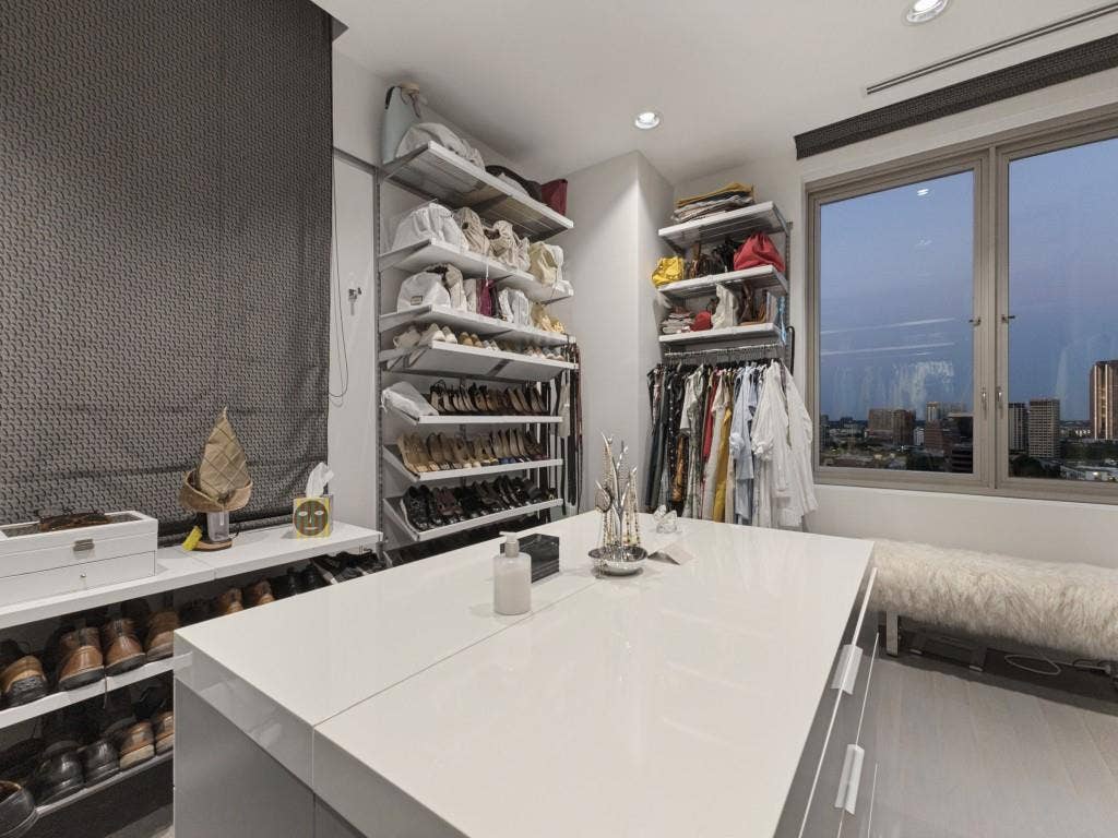 2300 Wolf Street, #14A, Dallas, TX 75201 Built-in shelving units, central island with storage, window with urban backdrop, recessed lighting, and roller shade