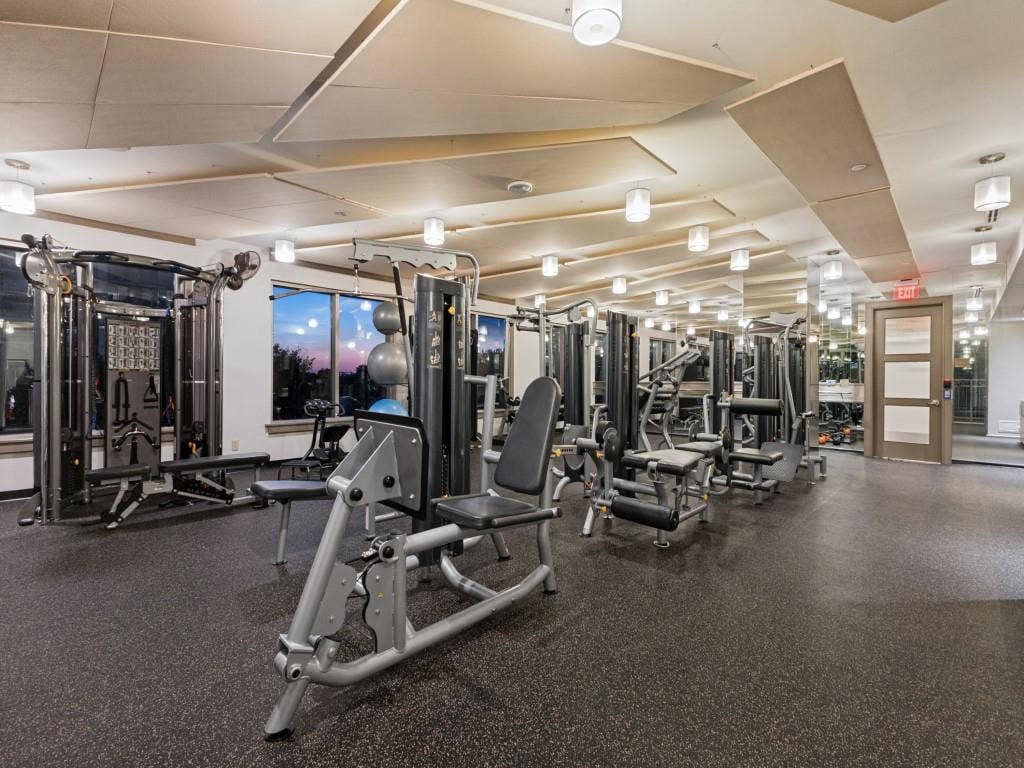 2300 Wolf Street, #14A, Dallas, TX 75201 Fitness center with extensive exercise equipment, resilient flooring, large windows, and contemporary ceiling light fixtures