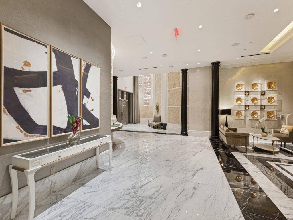 2300 Wolf Street, #14A, Dallas, TX 75201 Polished marble flooring throughout, accent wall with textured finish, recessed lighting, and decorative columns