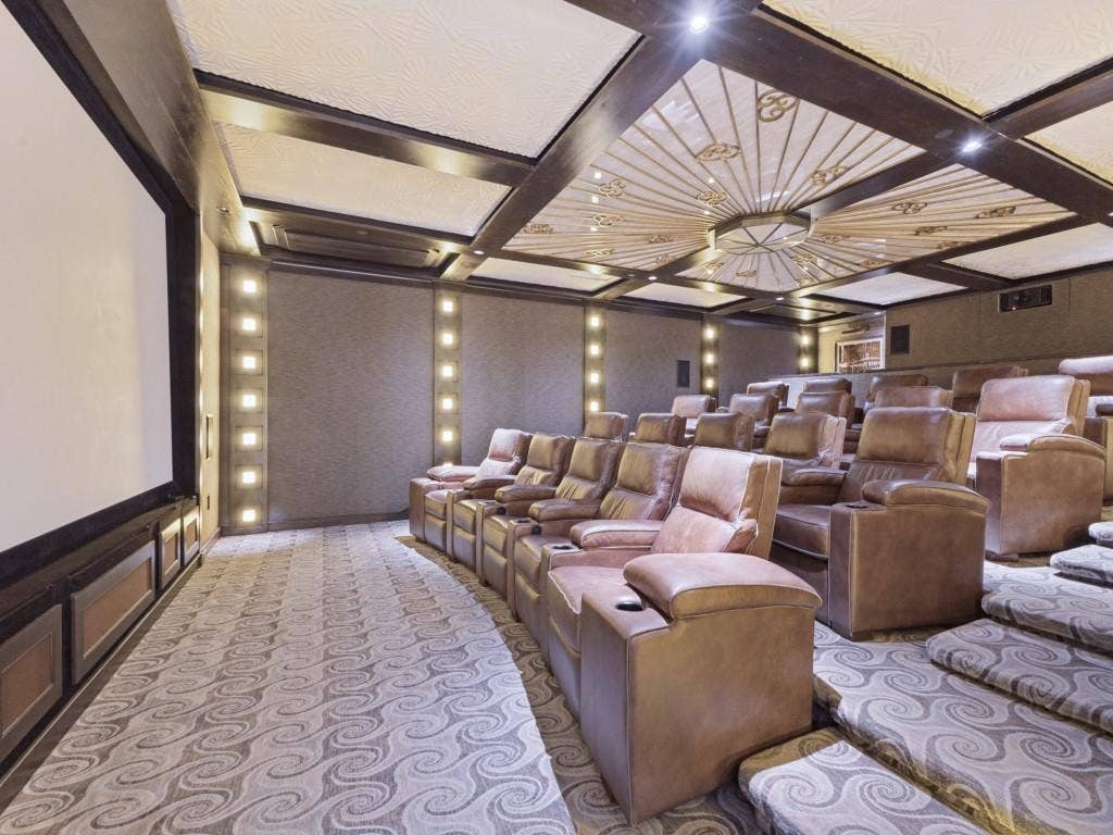 2300 Wolf Street, #14A, Dallas, TX 75201 Dedicated home theater with tiered seating, large projection screen, and patterned wall-to-wall carpeting