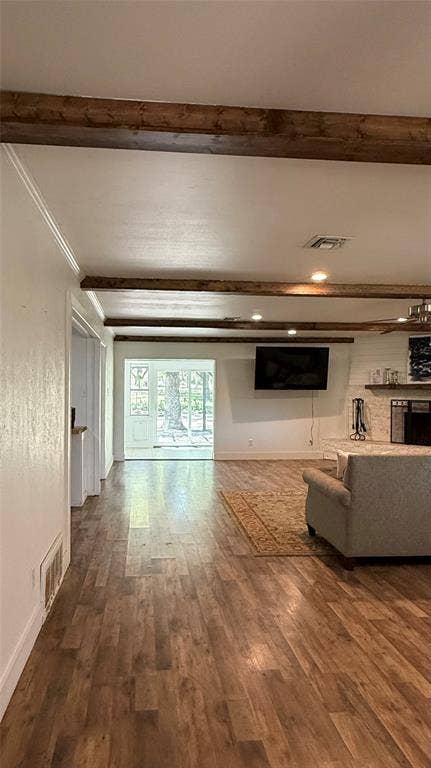 8513 Ravenswood Road, Granbury, TX 76049 Exposed wood beams, recessed lighting, wood-finish flooring, and white walls create a bright interior