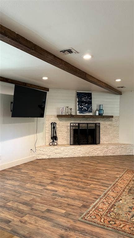 8513 Ravenswood Road, Granbury, TX 76049 Exposed wood beams, recessed lighting, wood-finish flooring, stone-clad fireplace with mantel, and shiplap accent wall