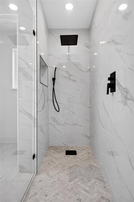15166 FM 3133, Anna, TX 75409 Spacious shower enclosure featuring full-height marble-look tile walls, a herringbone-patterned floor, and frameless glass door