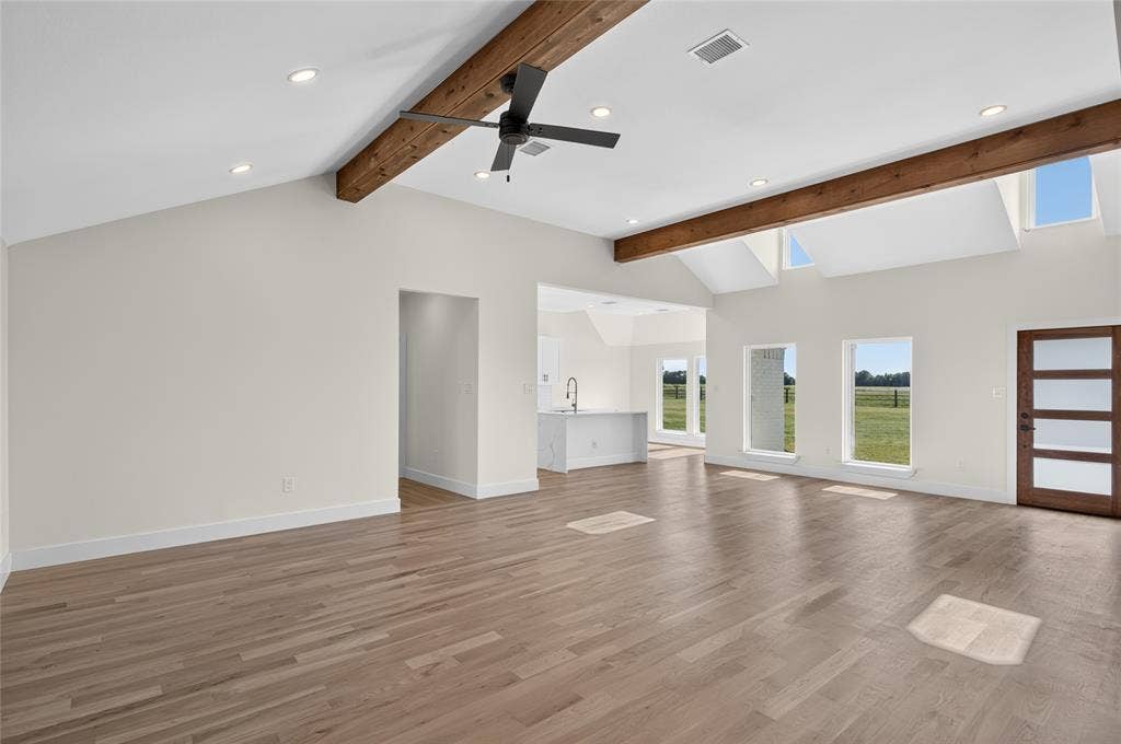 15166 FM 3133, Anna, TX 75409 Spacious living area featuring wood-finish flooring, vaulted ceilings with exposed beams, and recessed lighting