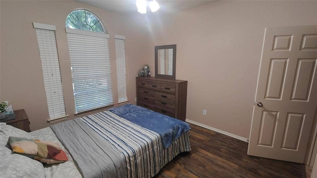 7004 Canyonbrook Drive, Plano, TX 75074 Wood-finish flooring, ceiling fan with light fixture, and arched window with blinds