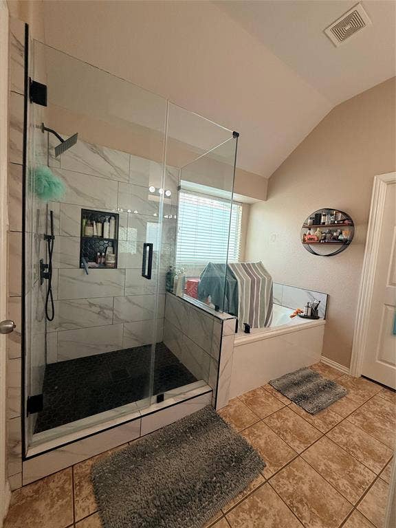 7004 Canyonbrook Drive, Plano, TX 75074 Glass-enclosed shower with a rainfall showerhead, tiled accent niche, and dark hexagonal tile flooring