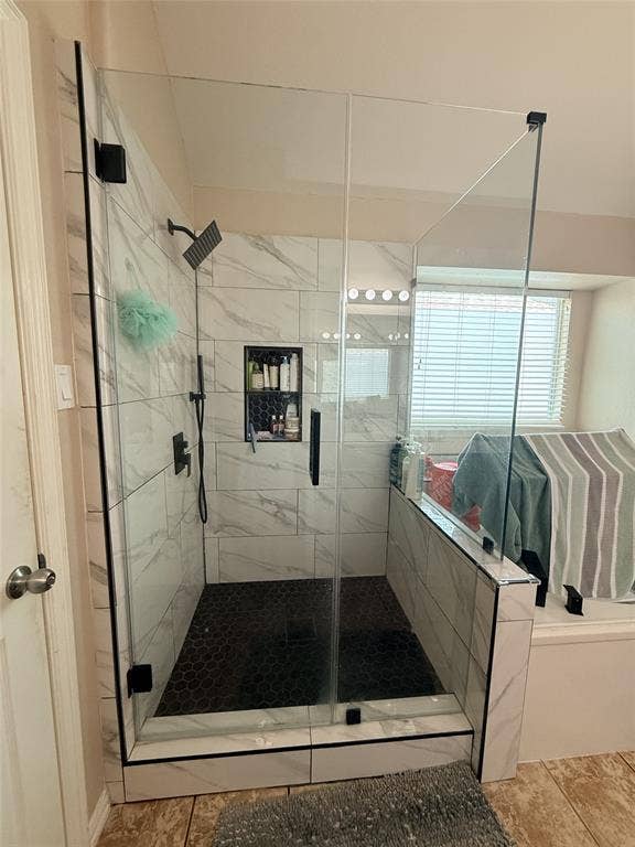 7004 Canyonbrook Drive, Plano, TX 75074 Glass-enclosed shower with black hexagonal tile flooring and white marble-look wall tile