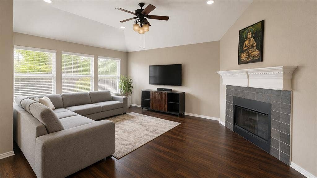 7004 Canyonbrook Drive, Plano, TX 75074 Vaulted ceilings with recessed lighting, wood-finish flooring, a fireplace with a white mantel and tile surround, and multiple windows with blinds