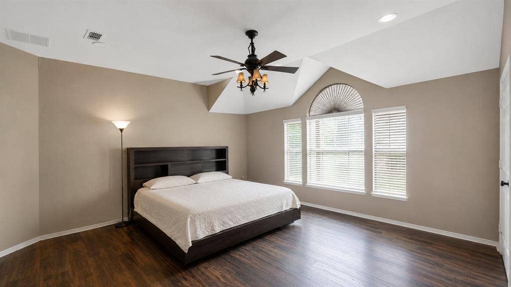 7004 Canyonbrook Drive, Plano, TX 75074 Vaulted ceiling with a ceiling fan light fixture, wood-finish flooring, and arched window with two rectangular windows