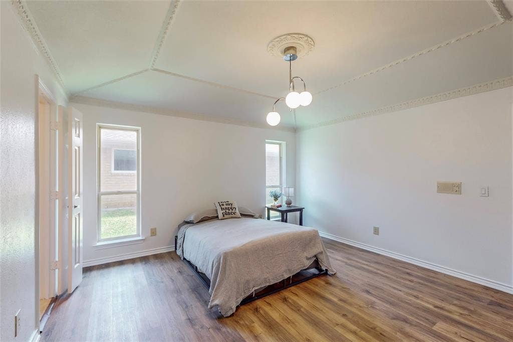 Wood-finish flooring, white walls, and a decorative ceiling medallion