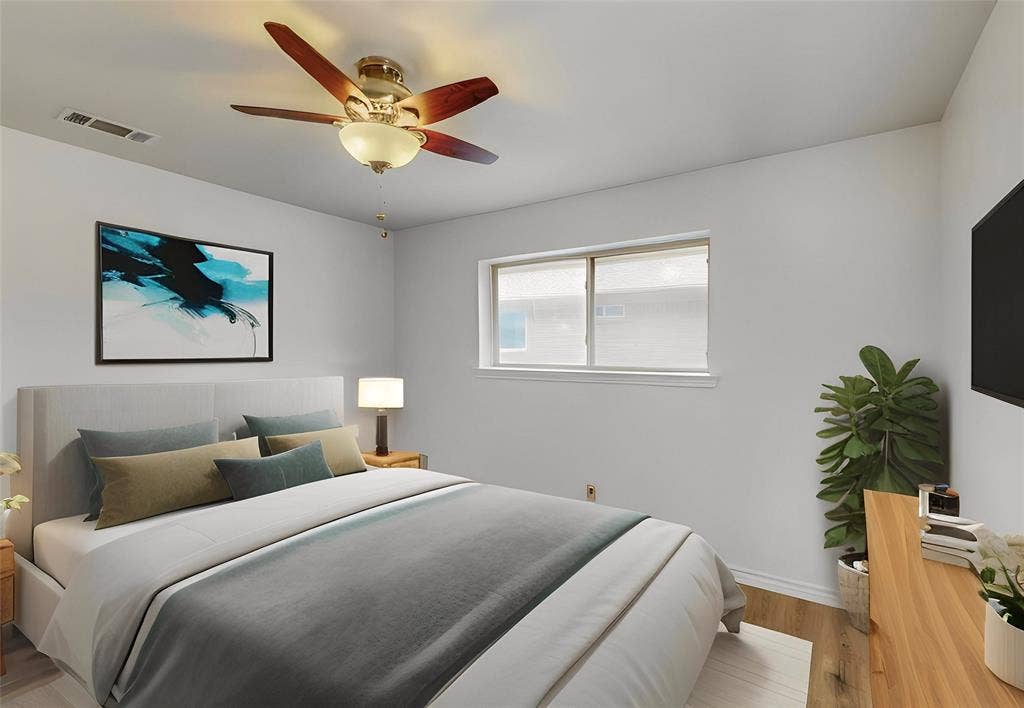 Overhead ceiling fan with integrated lighting, window with roller shade, wood-finish flooring, wall-mounted television