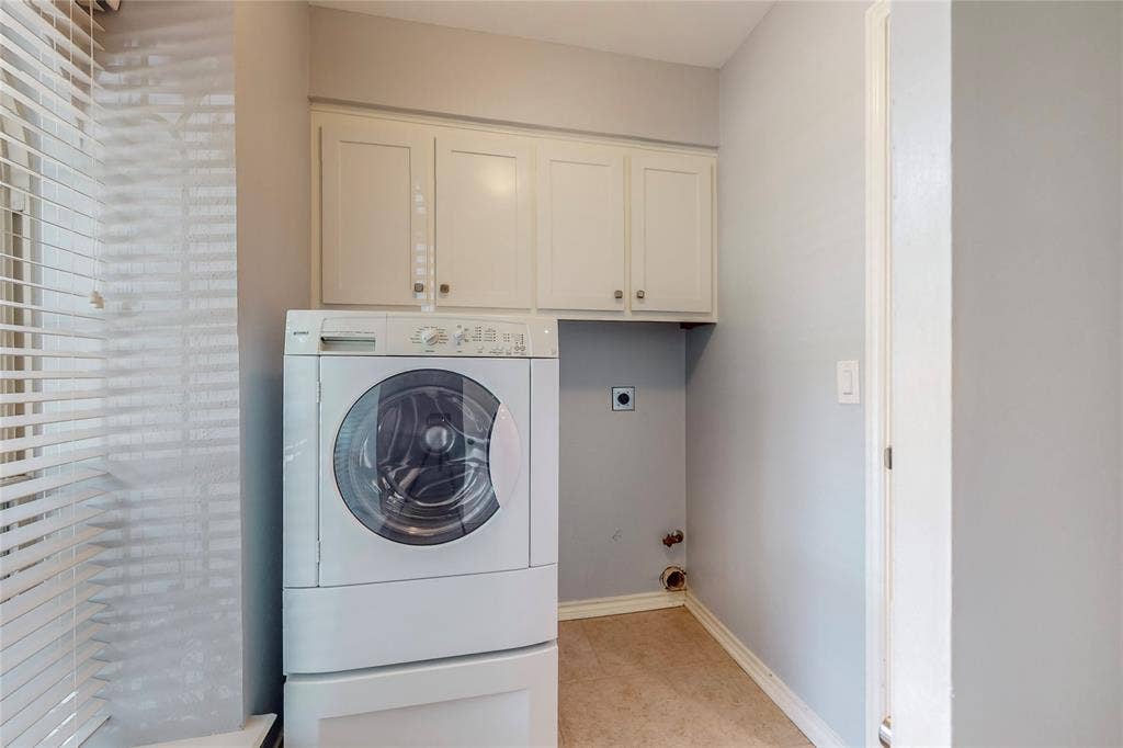 Built-in cabinetry with silver-tone hardware, tile flooring, and light gray wall paint