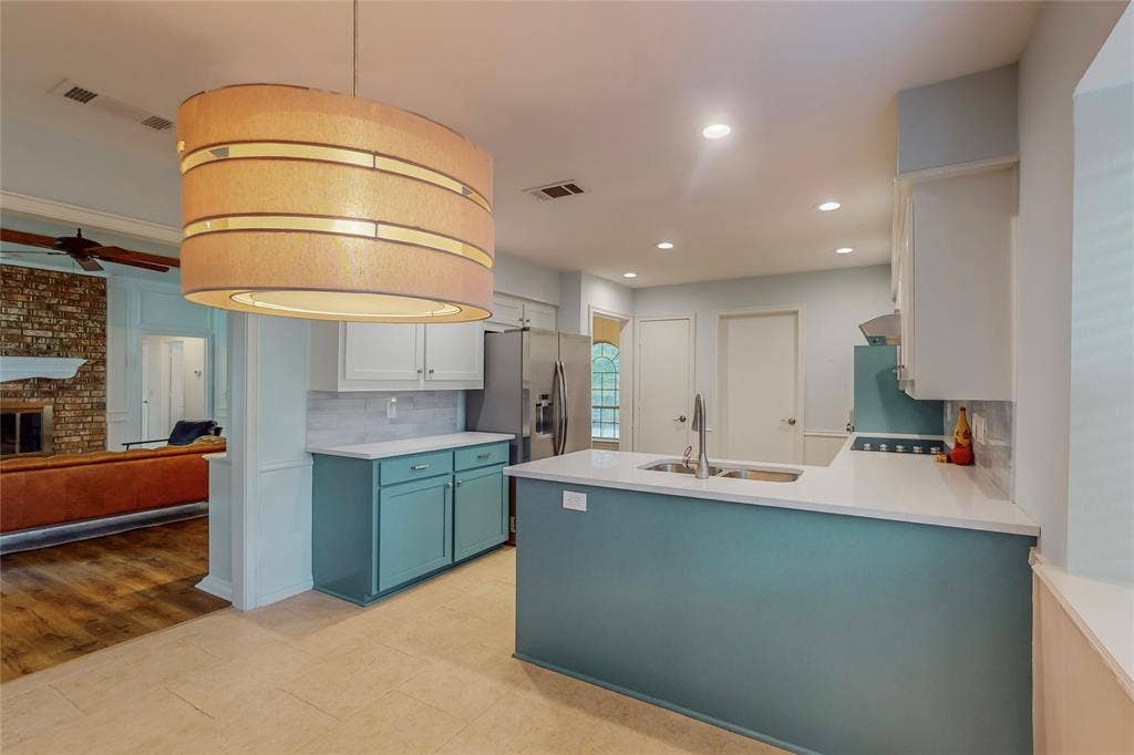 Recessed lighting, tile flooring, stainless steel appliances, solid surface countertops, and a subway tile backsplash
