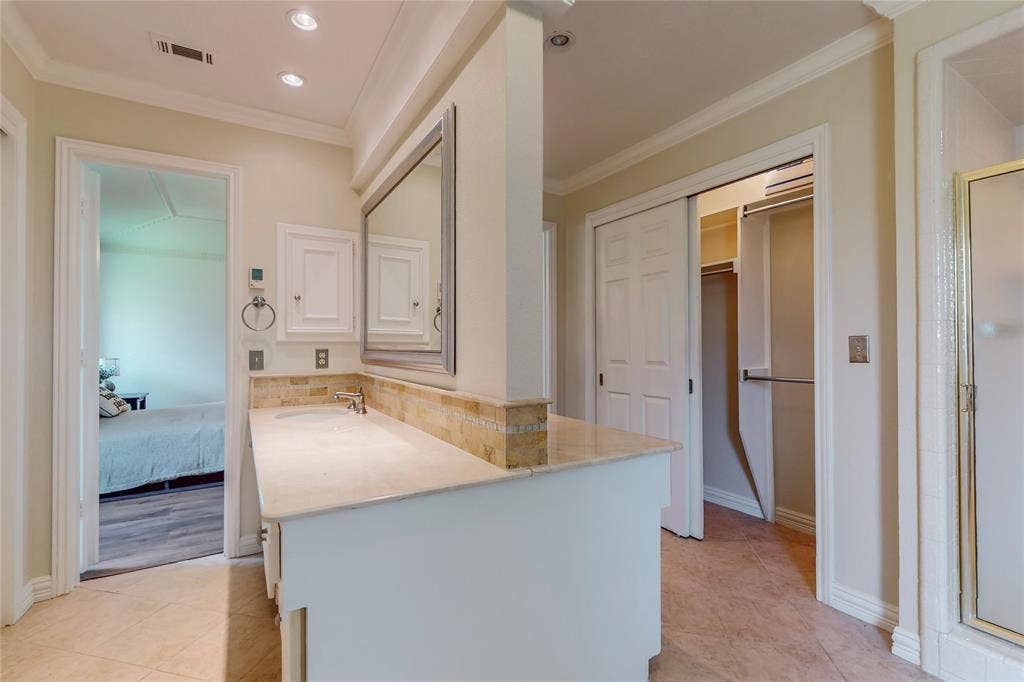 Vanity with stone countertop and backsplash, undermount sink, and recessed lighting