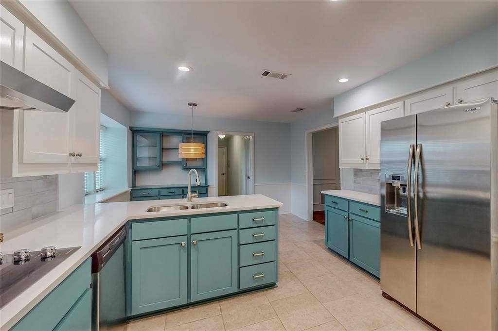 Kitchen featuring white shaker upper cabinetry and teal lower cabinetry, white countertops, tile flooring, and stainless steel appliances