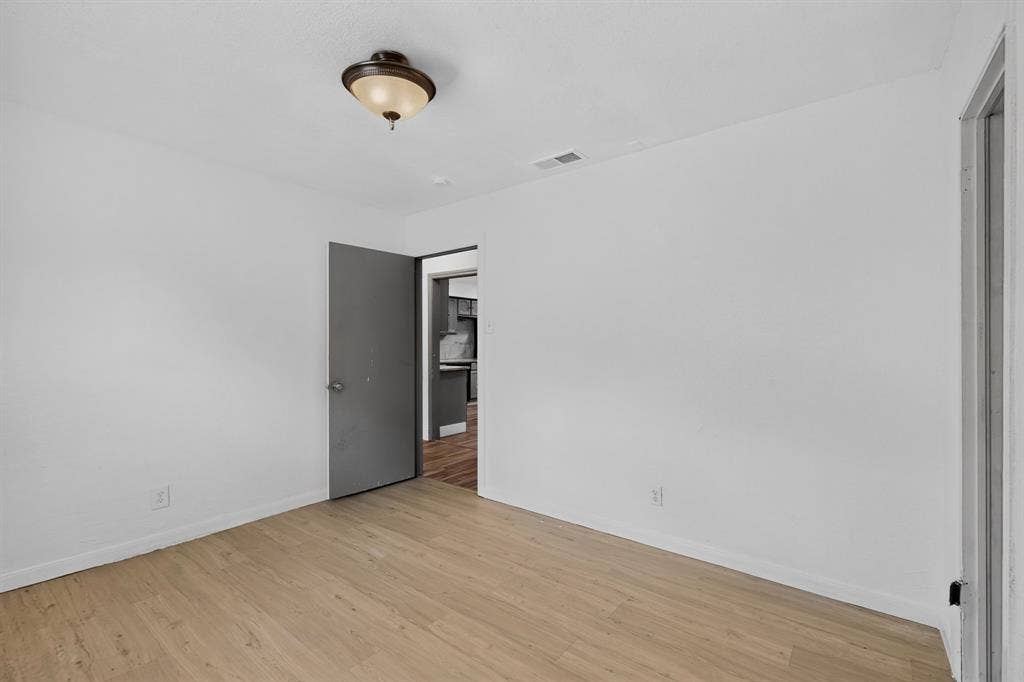 Interior space featuring wood-finish flooring, a semi-flush mount light fixture, and a neutral color palette