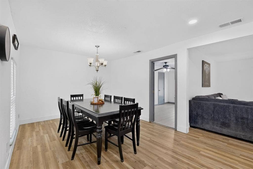 Dining area featuring wood-finish flooring, a multi-arm chandelier, and recessed lighting