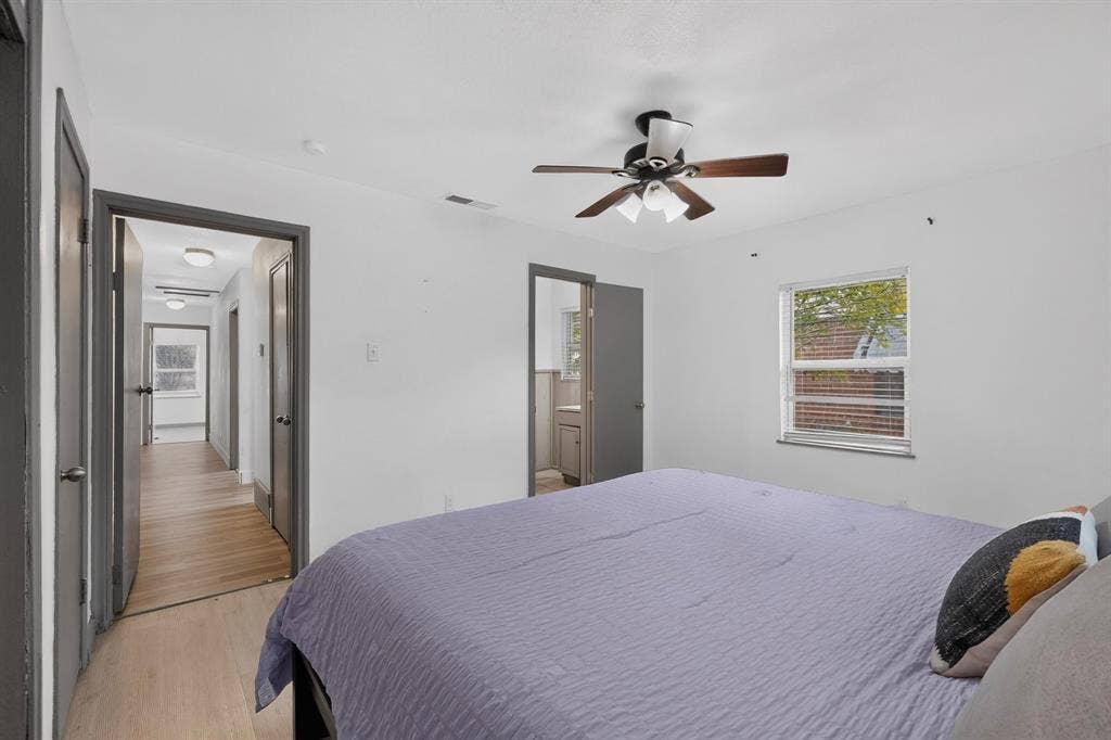Room featuring a ceiling fan with integrated lighting, a multi-pane window, and contrasting door trim