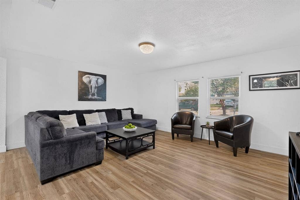 Interior room featuring wood-finish flooring, two dual-pane windows, and a flush-mount ceiling light fixture