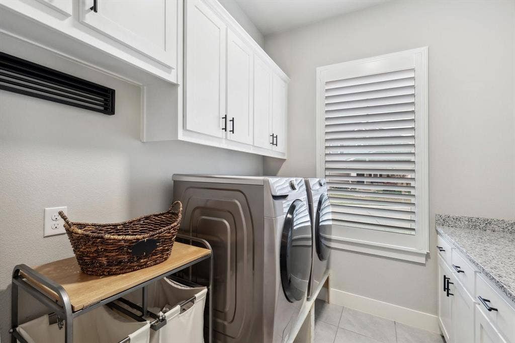 White shaker cabinetry with matte black hardware, a window with louvered blinds, and a speckled countertop