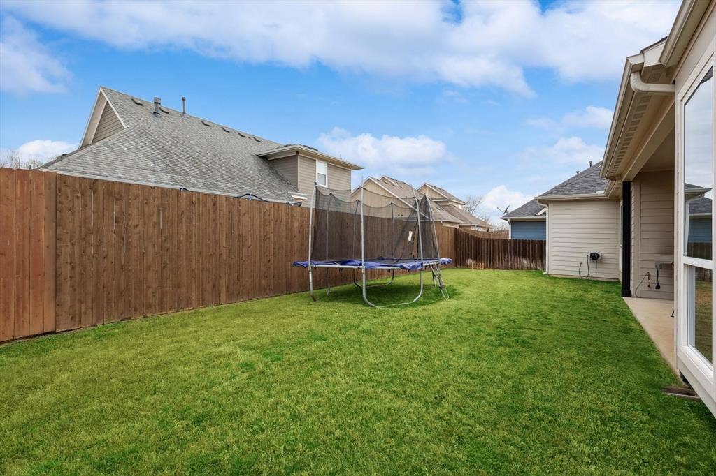 Expansive grassy lawn with a wood privacy fence
