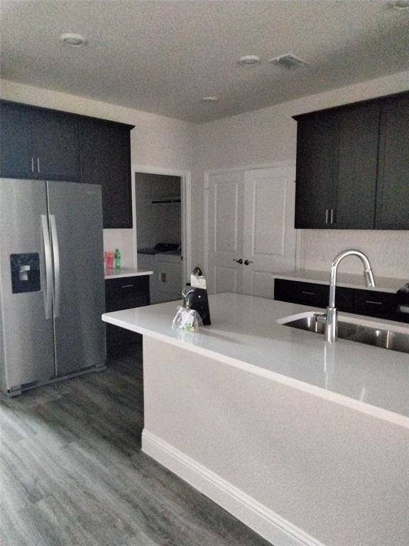 601 Willet Drive, McKinney, TX 75069 Kitchen featuring a center island, stainless steel refrigerator, dark wood-finish cabinetry, and a stainless steel sink with a high-arc faucet